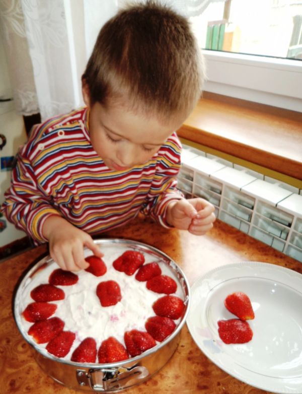 Piotrek 5lat dekoruje sernik swoimi ulubionymi owocami